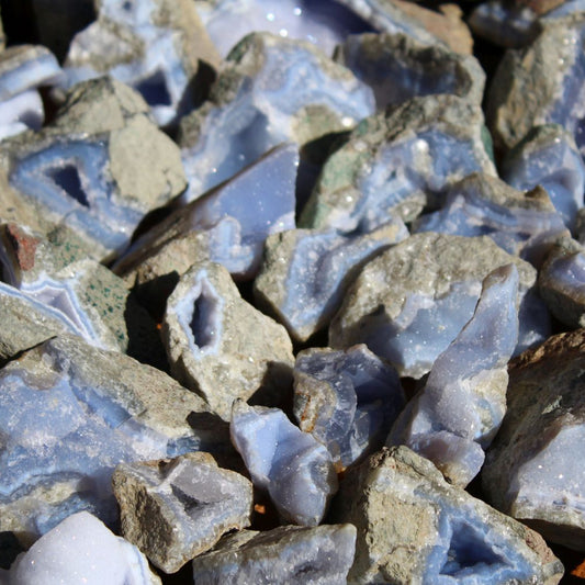 Wholesale Blue Lace Agate rough specimens from Nsanje, Malawi – multiple cleaned pieces showing variable blue chalcedony coloration and basalt matrix, natural rough finish | SKU BLAperkg