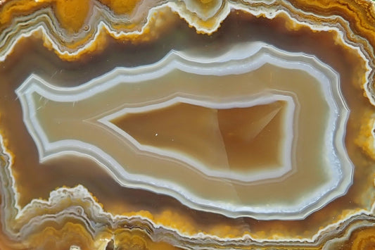 Ghost Mountain agate 71 mm, detail of angular white and blue-grey fortification bands enclosing the pointed brown centre, with beige, brown and golden-yellow layers, South Africa.