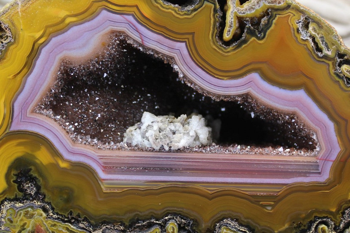 Lilangabi agate 128 mm – close-up of lavender-purple chalcedony band, open druzy vug with white calcite crystal cluster on vug floor | SKU LIL00008