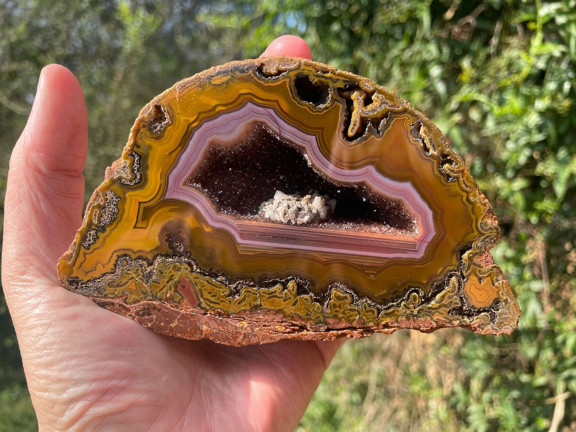 Lilangabi agate 128 mm – in-hand size reference, purple chalcedony band and druzy vug visible, Eswatini | SKU LIL00008