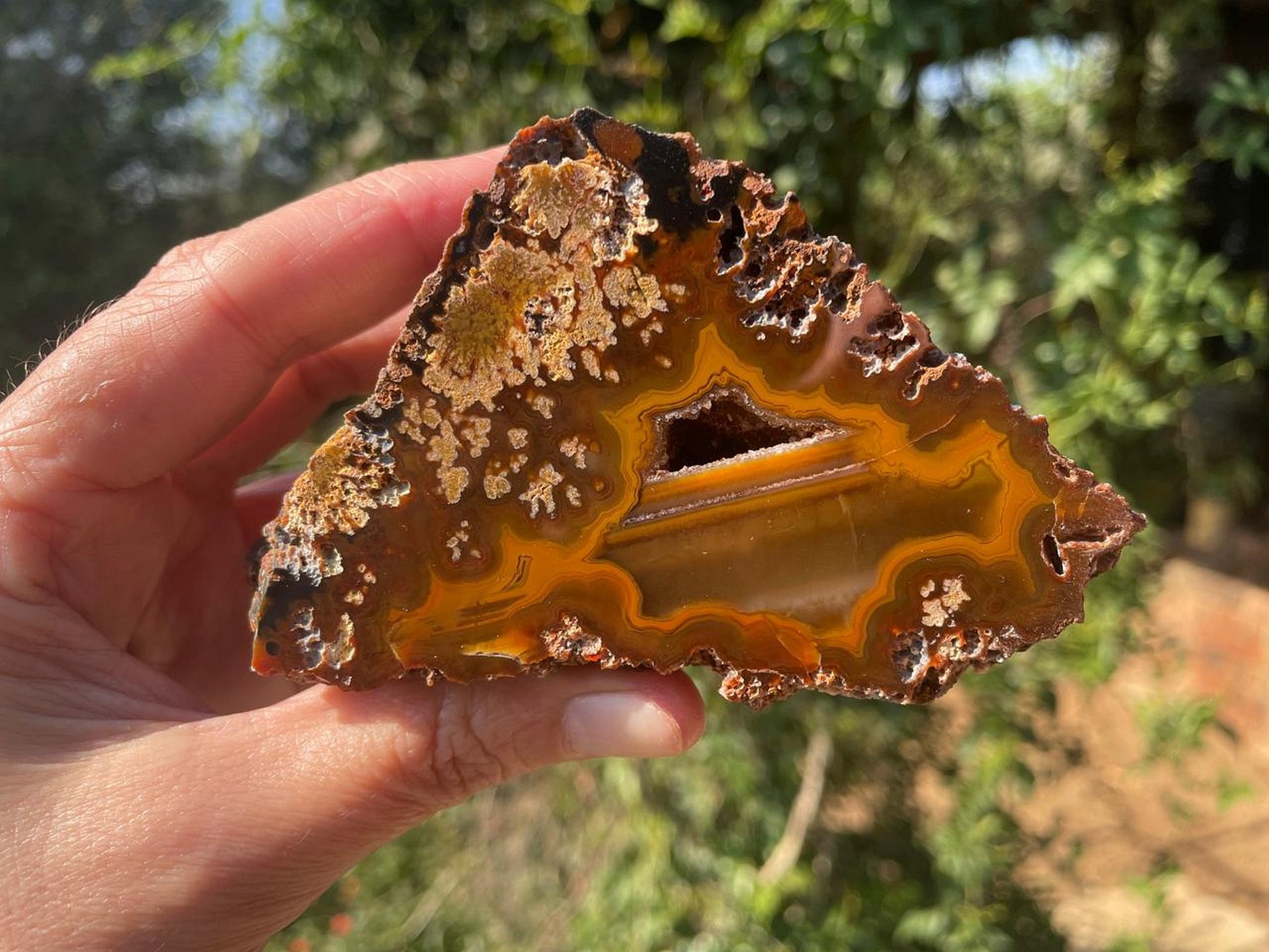 Lilangabi agate 98mm – in-hand, open vug and dendritic inclusions visible | SKU LIL00016