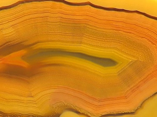 Lilangabi agate 69 mm – close-up of scalloped banding and shadow banding, alternating translucent and opaque bands, amber-golden palette | SKU LIL00034