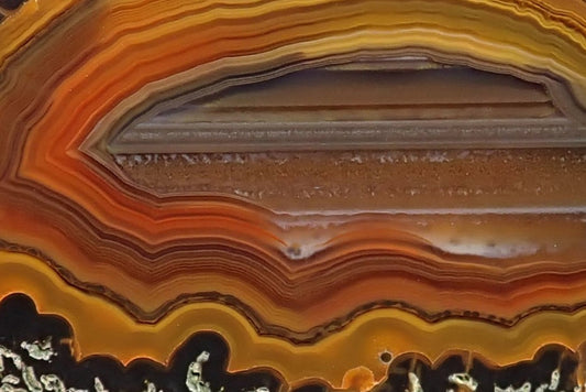 Lilangabi agate 66 mm – close-up of waterline centre and fortification banding, amber and sard-carnelian tones, Eswatini