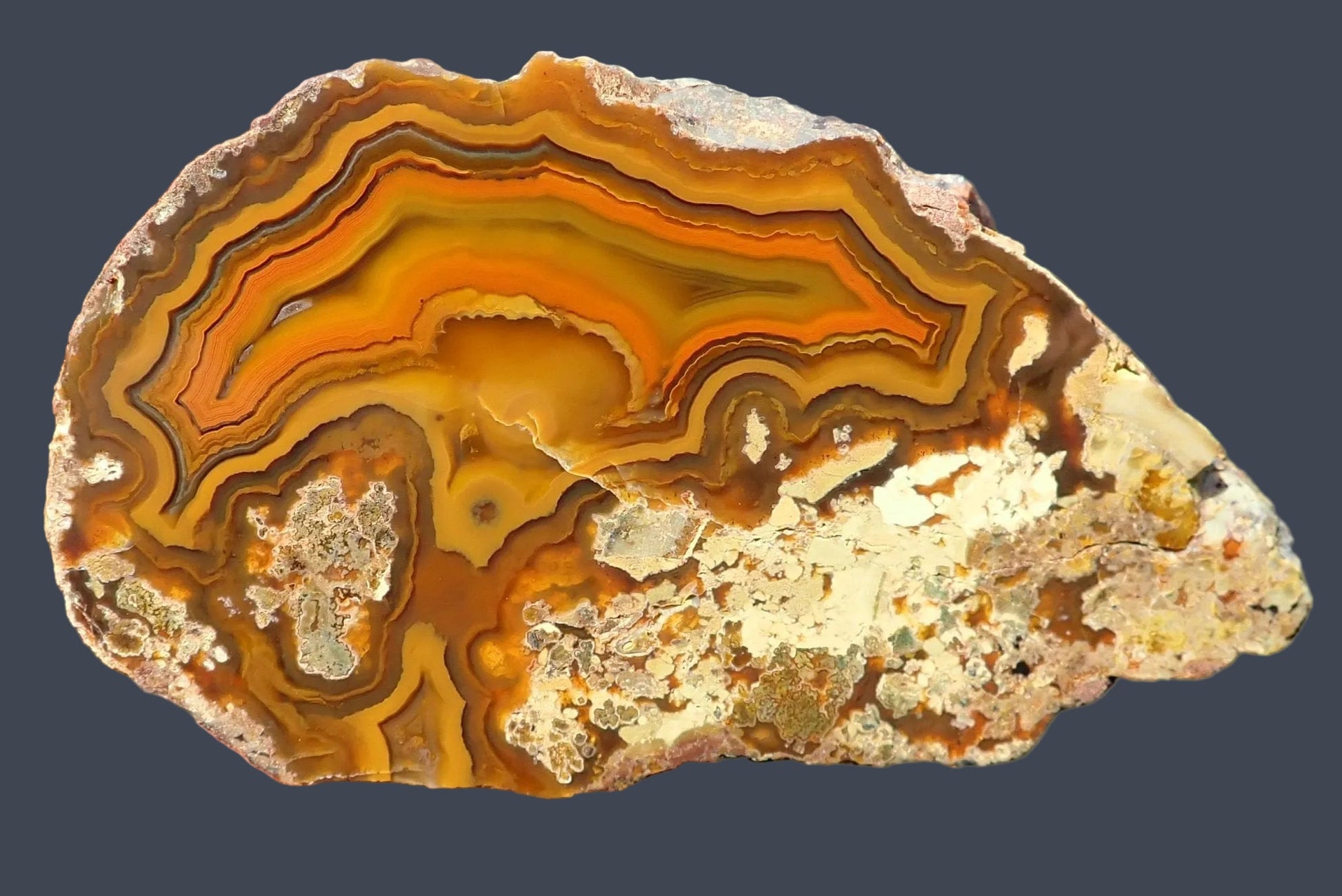 Lilangabi agate 85 mm – front face, angular fortification banding, deep amber and burnt orange chevron layers, golden centre