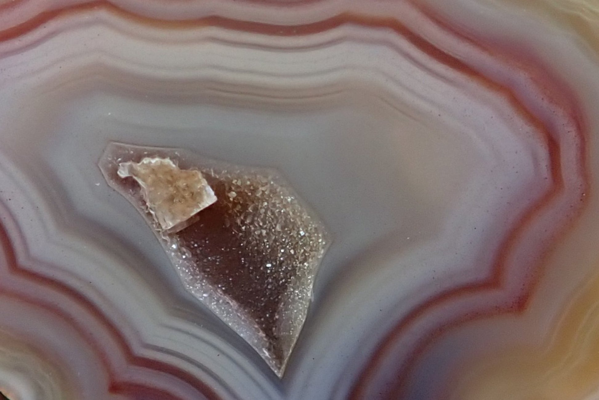 Malawi agate 47 mm – face detail, angular fortification bands, drusy vug with calcite crystal point, cream to mauve-purple