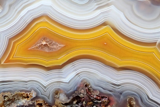 Malawi agate 57 mm, detail of golden yellow fortification bands bordered by fine white and pale grey ghost banding, with darker grey scalloped layers below, Ngabu, Malawi.