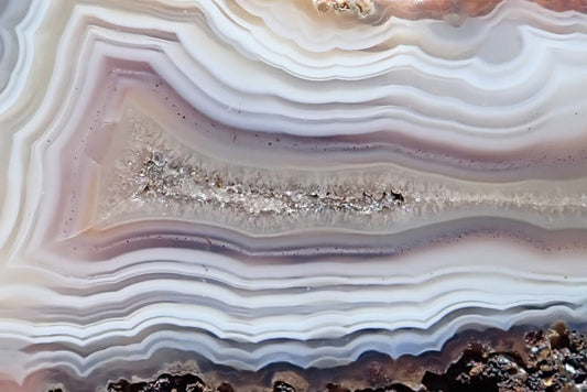 Malawi agate 66 mm, crystalline centre detail with ghost banding and closely spaced white, grey and pale mauve bands, Ngabu, Malawi.