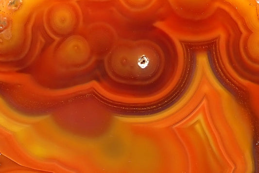Malawi agate 74 mm – detail of concentric eyes and fine reddish-brown fortification bands bordering golden yellow and orange layers, from Ngabu, Malawi.