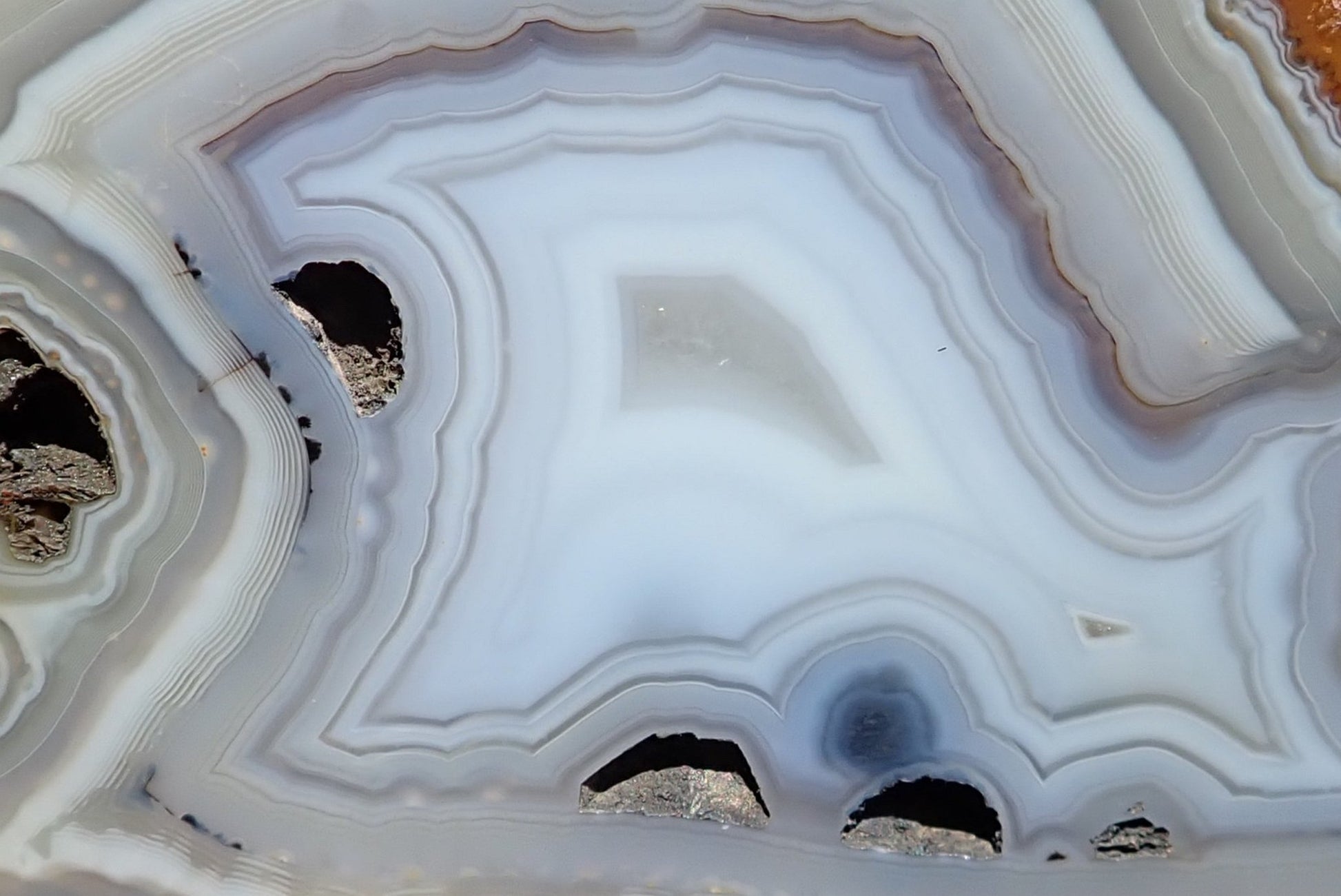 South African agate 102 mm – detail of flow channels cutting through pale grey and white banding layers