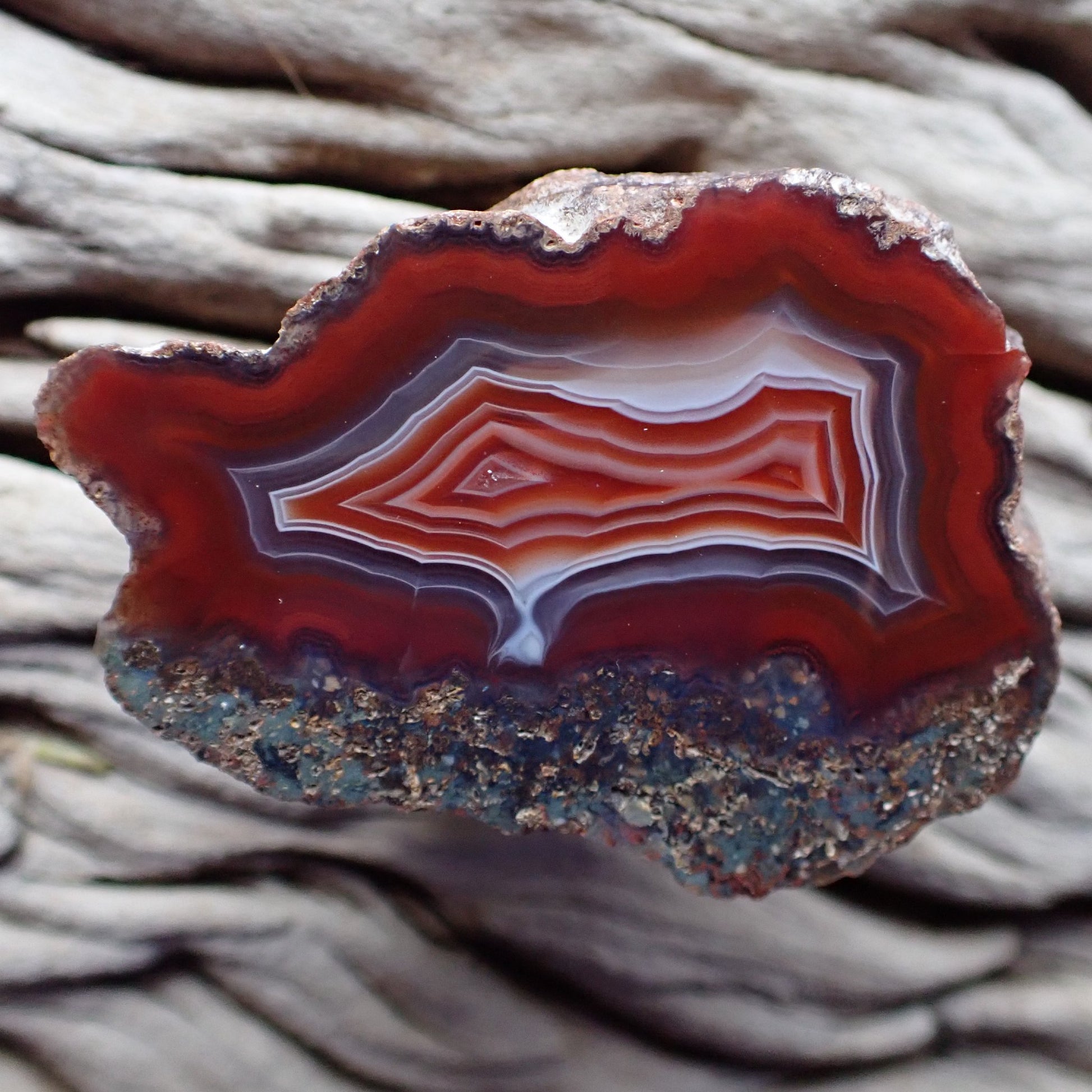 Polished Malawi agate from the Ngabu region with bold red colouring and ghost banding exiting into a flow channel