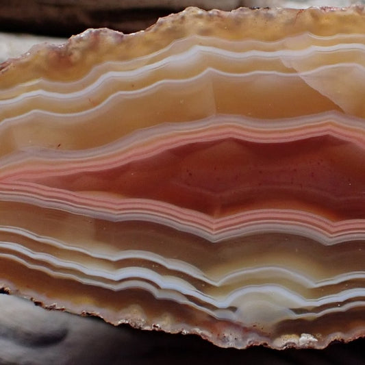Close-up of a Malawi candy agate with ghost banding. Colours from a lovely salmon/pink/brown going into peach and red colours