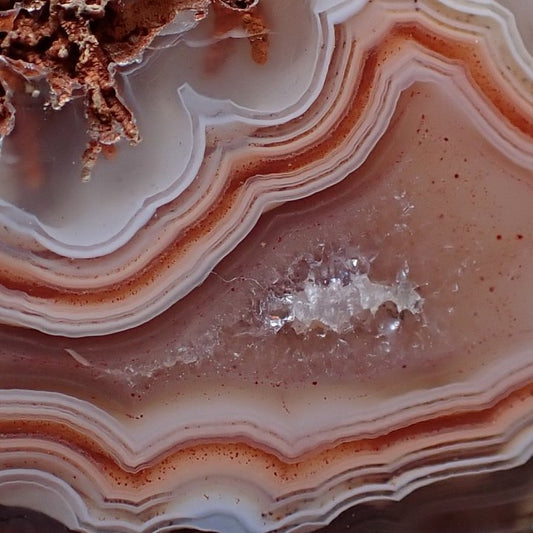 Close up of the crystalline centre of a Malawi agate ringed by brown / red / salmon bands
