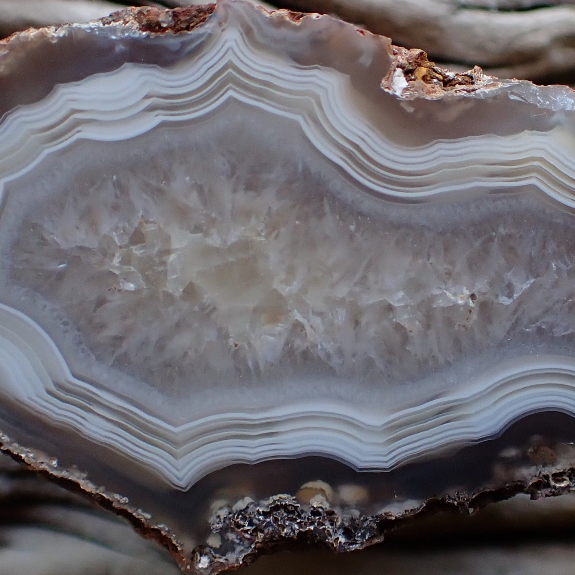close up of the crystalline centre of a polished Malawi agate surrounded by white ands with strong parallax