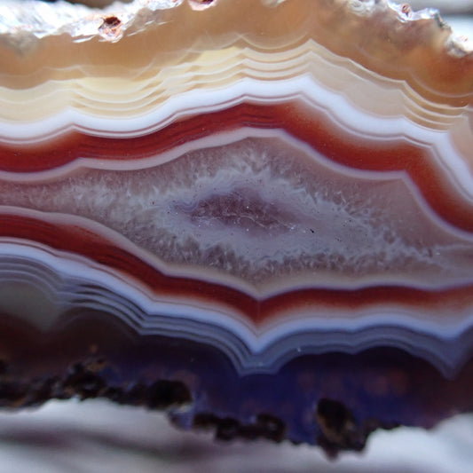 Close-up of a layered Malawi agate stone with red and white banding