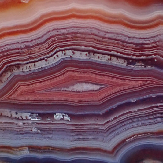Close-up of layered Malawi Ngabu agate with red, purple, and white colors