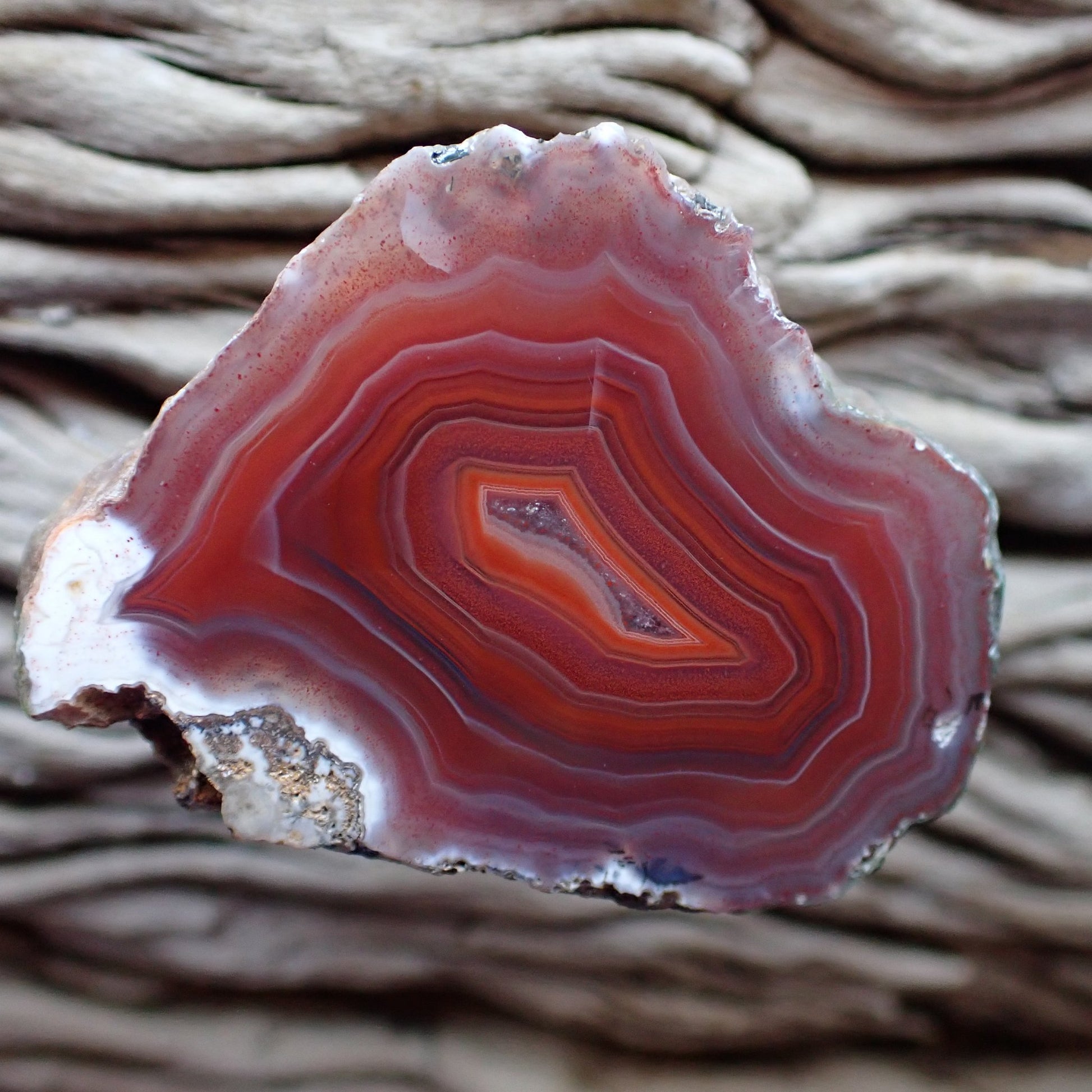 A red and white with a small crystalline centre banded in bright orange banded Malawi agate stone