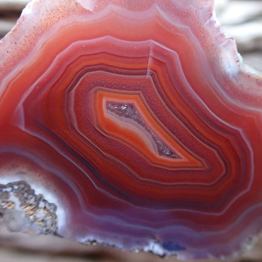Close-up of a red and white banded Malawi agate with an orange band around a crystalline centre