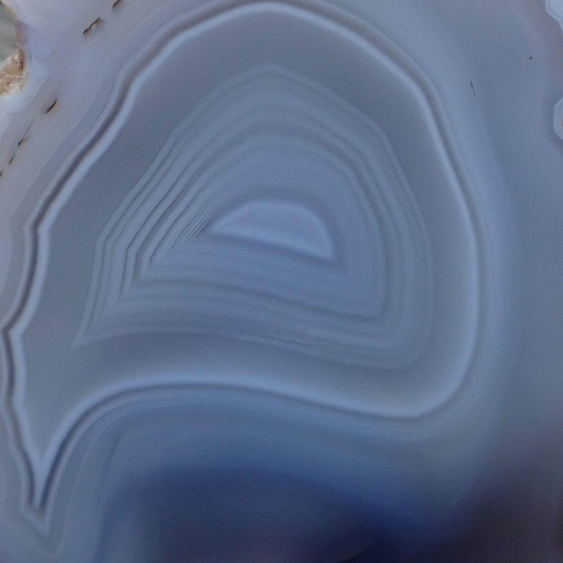 close-up of the centre of a polished Malawi Ngabu agate with layers of white, grey and pale blue