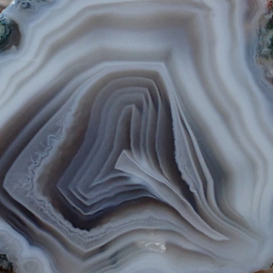 close up of a white and grey polished Malawi Ngabu agate's cray lace banding and distinct flow channel