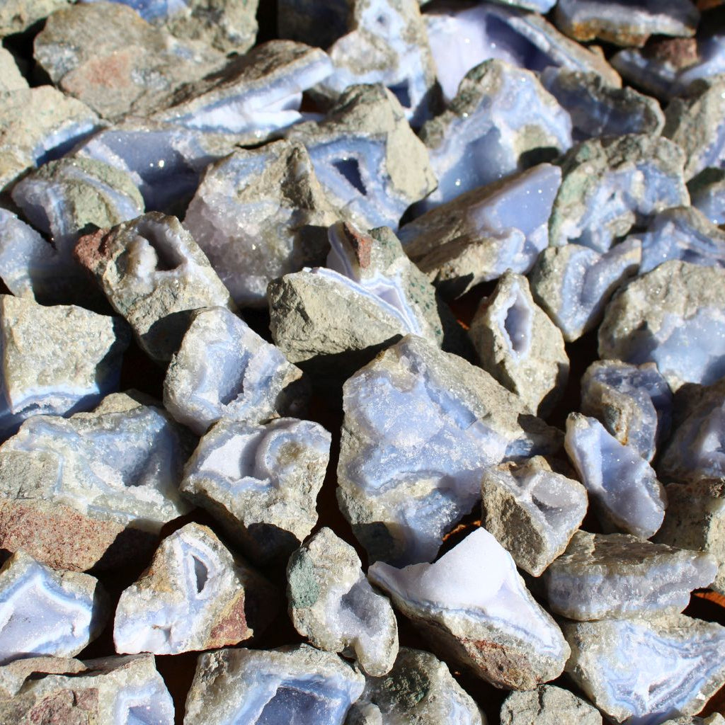 Wholesale Blue Lace Agate rough specimens, Nsanje Malawi – angled close-up showing vug cavities, banding detail and basalt host rock, natural rough finish | SKU BLAperkg