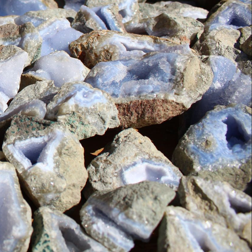 Wholesale Blue Lace Agate rough from Malawi – overhead view of cleaned specimens displaying open vug cavities and pale blue chalcedony faces | SKU BLAperkg