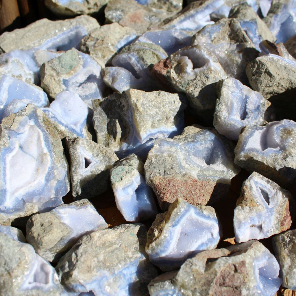 Wholesale Blue Lace Agate rough from Malawi – close-up of fractured chalcedony face showing layered blue-white banding and basalt host rock | SKU BLAperkg