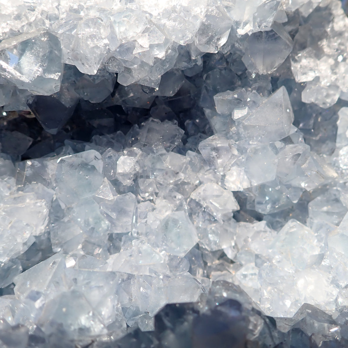 Celestite from Madagascar, close-up of overlapping pale blue tabular crystals and the recessed geode interior.