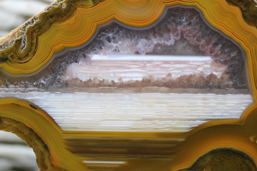 Lilangabi agate 86 mm – close-up of waterline deposition and scalloped fortification band edge, druzy vug cavity at base | SKU LIL00005
