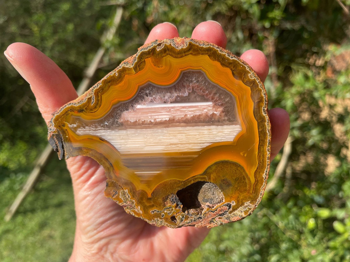 Lilangabi agate 86 mm – in-hand size reference, fortification banding and waterline features visible, Eswatini | SKU LIL00005