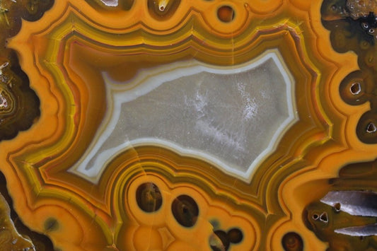 Lilangabi agate 103 mm – close-up of eyes and scalloped fortification banding, vivid tangerine-to-ochre chromatism | SKU LIL00003