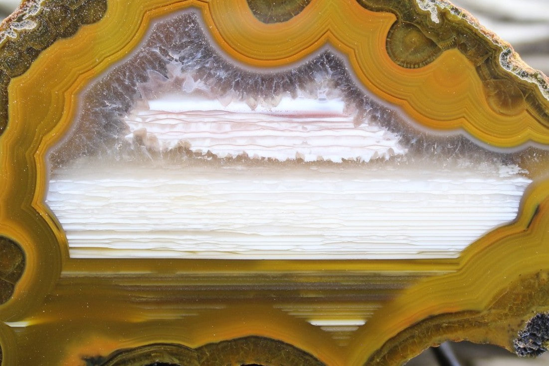  Lilangabi agate 87 mm – close-up of waterline deposition and crystalline quartz fringe, golden-amber fortification banding | SKU LIL00004