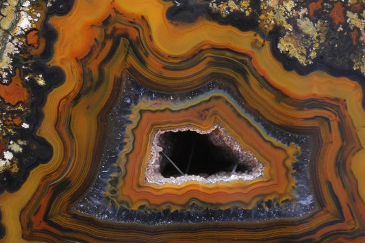 Lilangabi agate 114 mm – close-up of druzy vug with goethite needle inclusions, fortification banding and chromatism | SKU LIL00007
