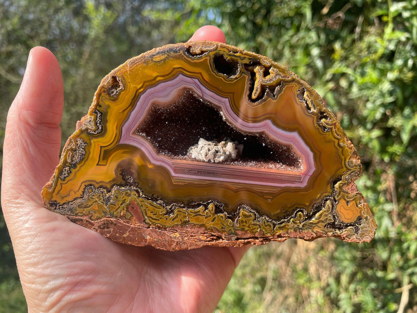 Lilangabi agate 128 mm – in-hand size reference, purple chalcedony band and druzy vug visible, Eswatini | SKU LIL00008