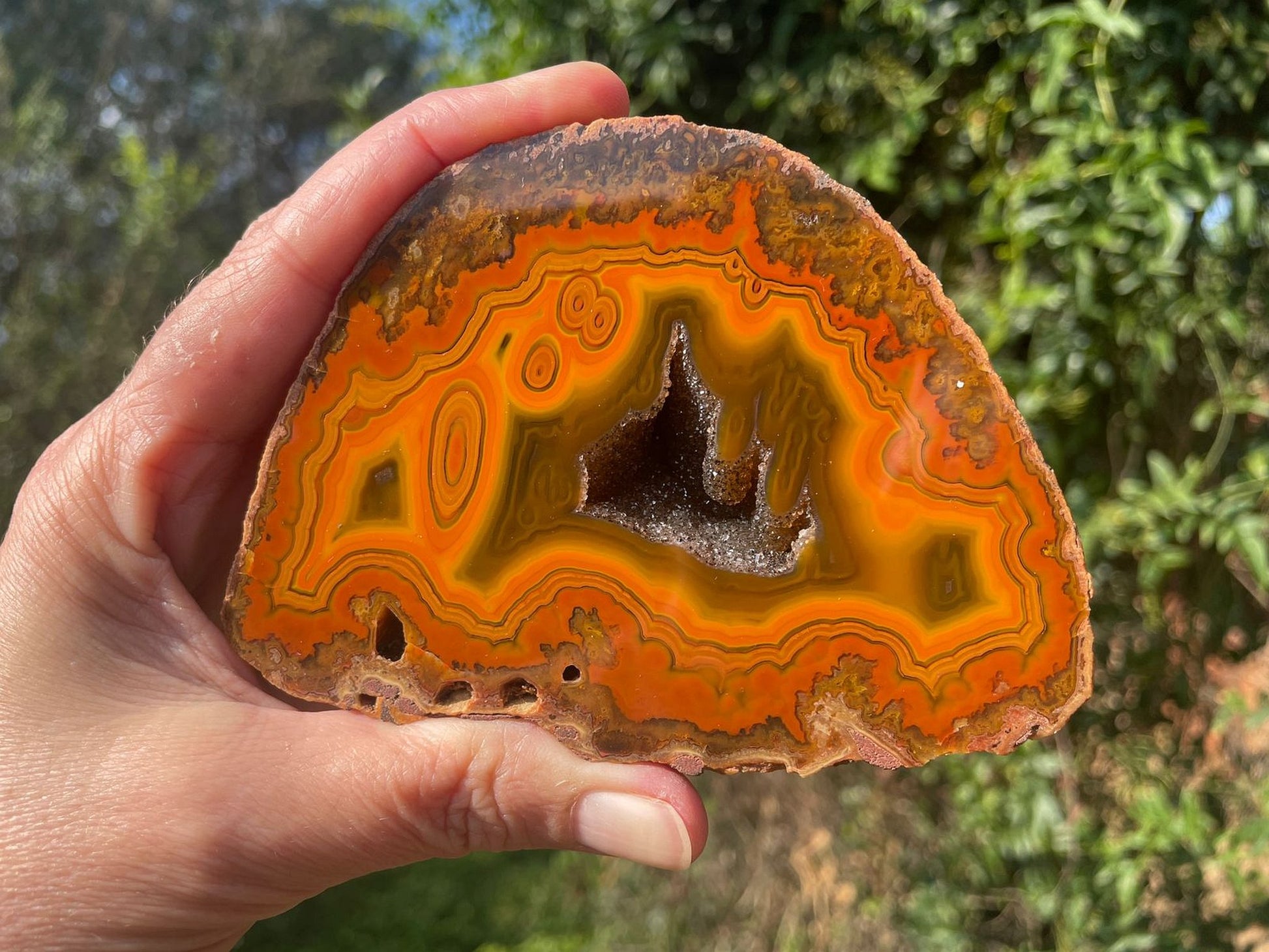 Lilangabi agate 108 mm – in-hand size reference, eyes and druzy vug visible, Eswatini | SKU LIL00010