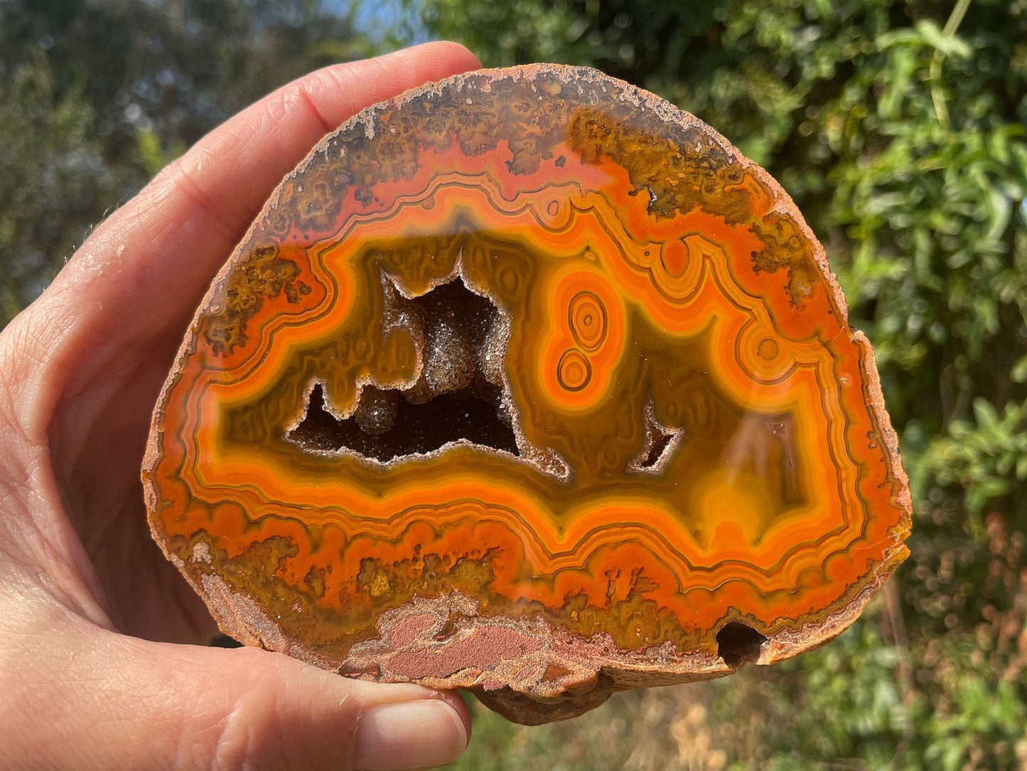 Lilangabi agate 107 mm – in-hand size reference, eyes and druzy vug visible, Eswatini | SKU LIL00011