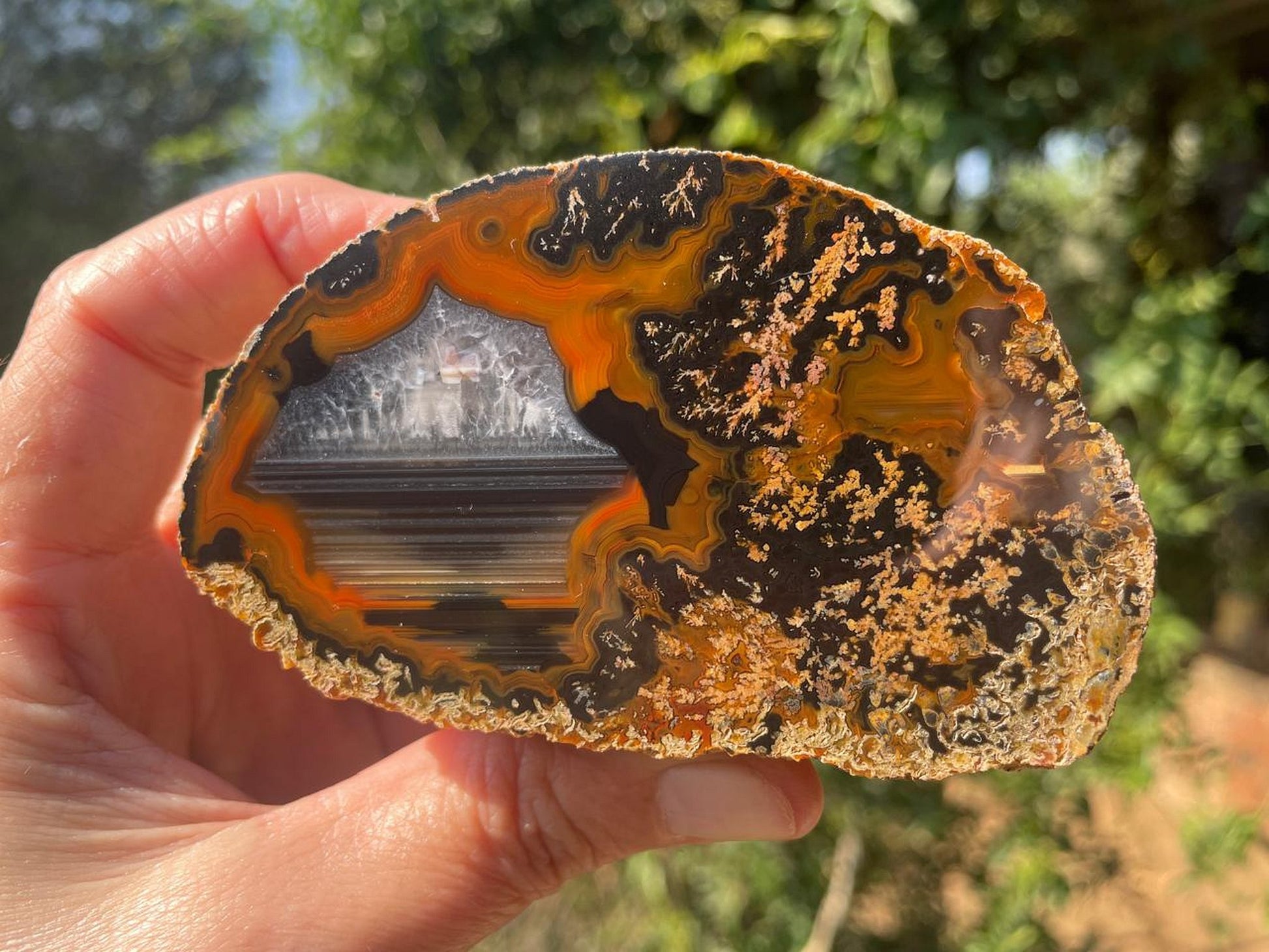 Lilangabi agate 90mm – in-hand, chalcedony centre and waterline section visible | SKU LIL00018
