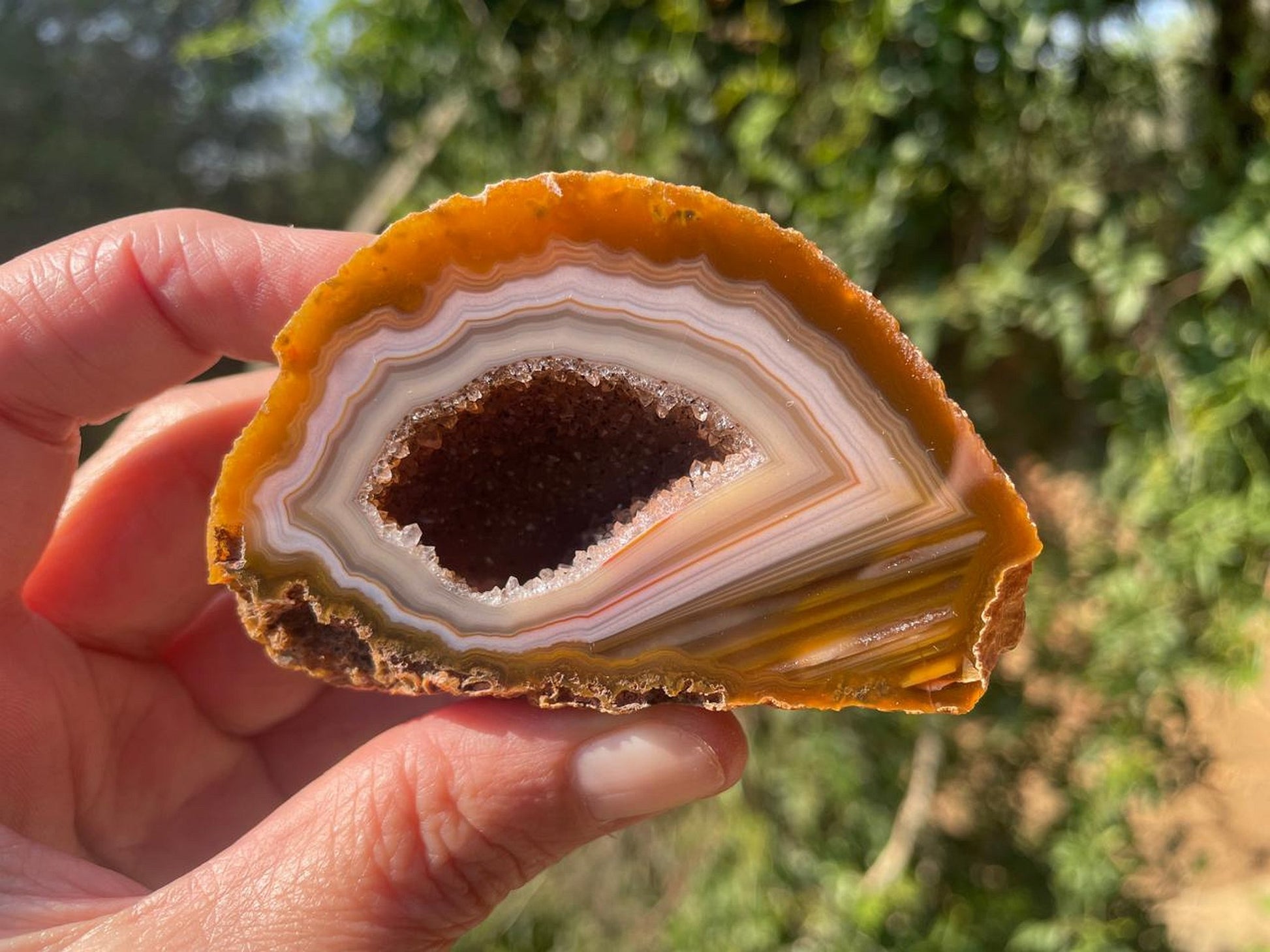 Lilangabi agate 88mm – in-hand, druzy vug and waterline section visible | SKU LIL00022