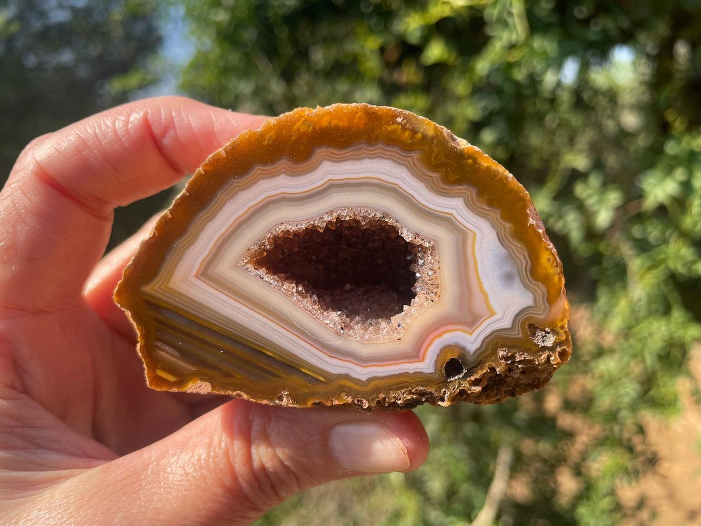 Lilangabi agate 74mm – in-hand, druzy vug and waterline section visible | SKU LIL00023