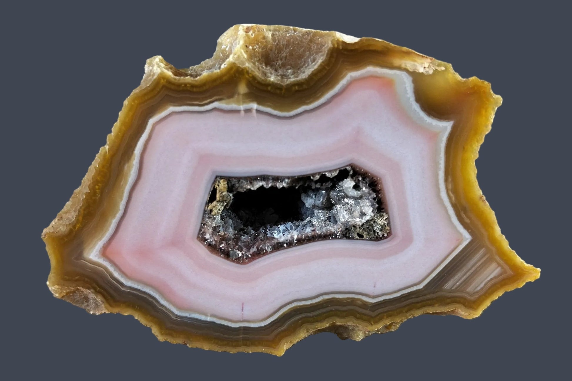 Lilangabi agate 100 mm – front face, druzy vug with quartz and calcite, pink chalcedony banding, amber outer band, Eswatini | SKU LIL00026