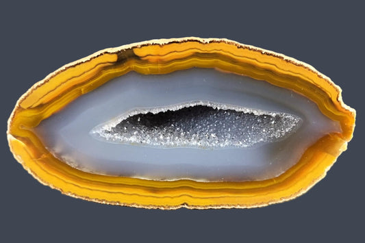 Lilangabi agate 107 mm – front face, elongated druzy vug, blue-grey chalcedony interior, amber scalloped banding, Eswatini | SKU LIL00027