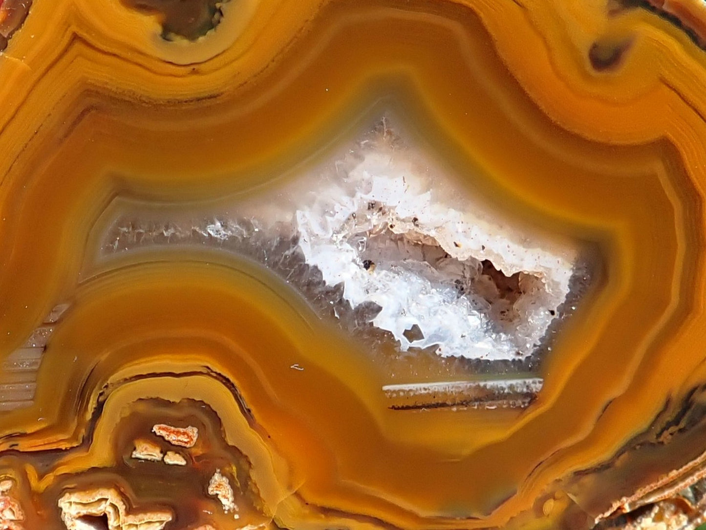 Lilangabi agate 58 mm – close-up of druzy vug, secondary chamber with waterlines, scalloped amber-golden banding | SKU LIL00035