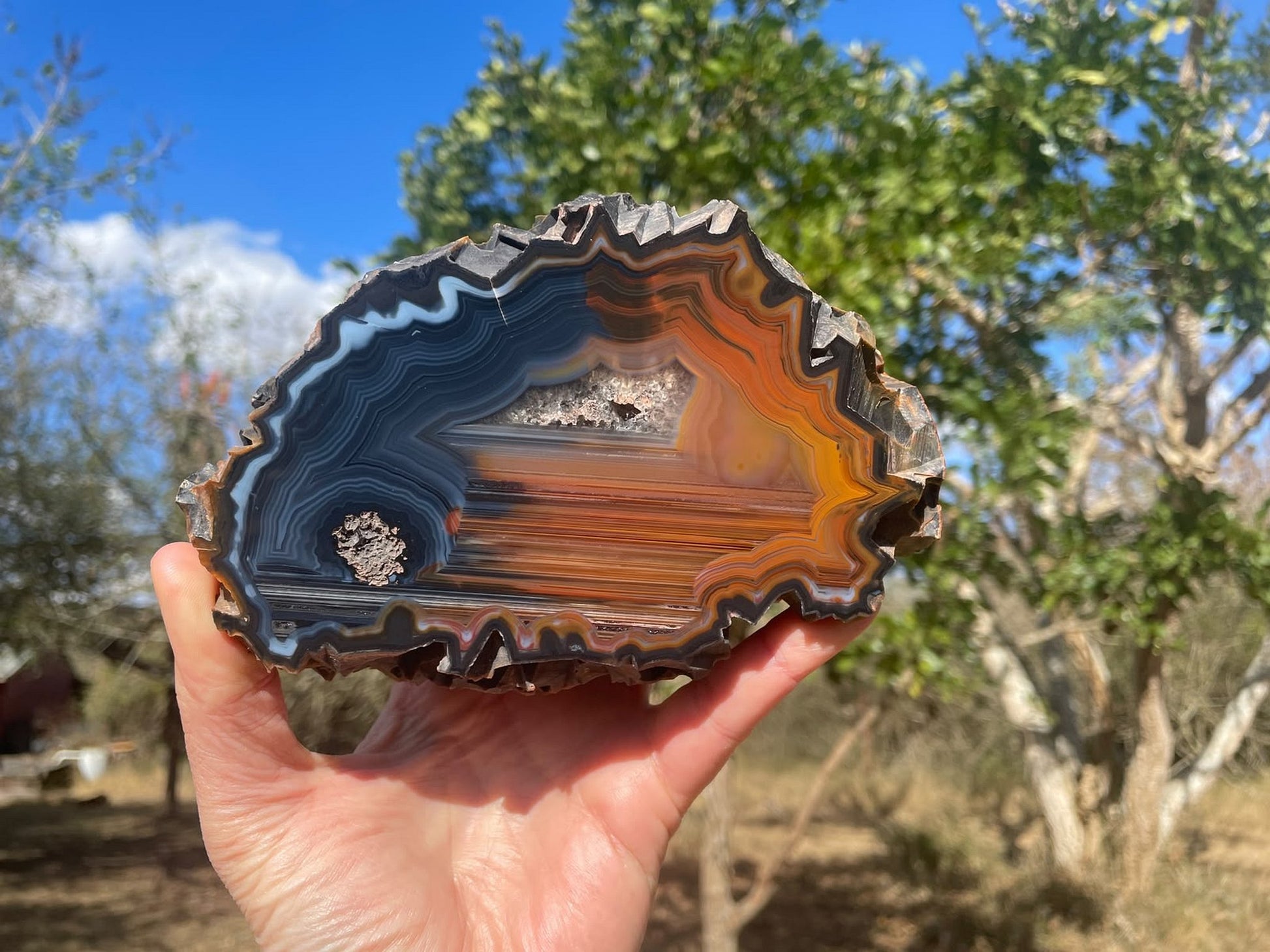 Lilangabi agate 146 mm – in-hand size reference, chromatism, fortification banding, Eswatini
