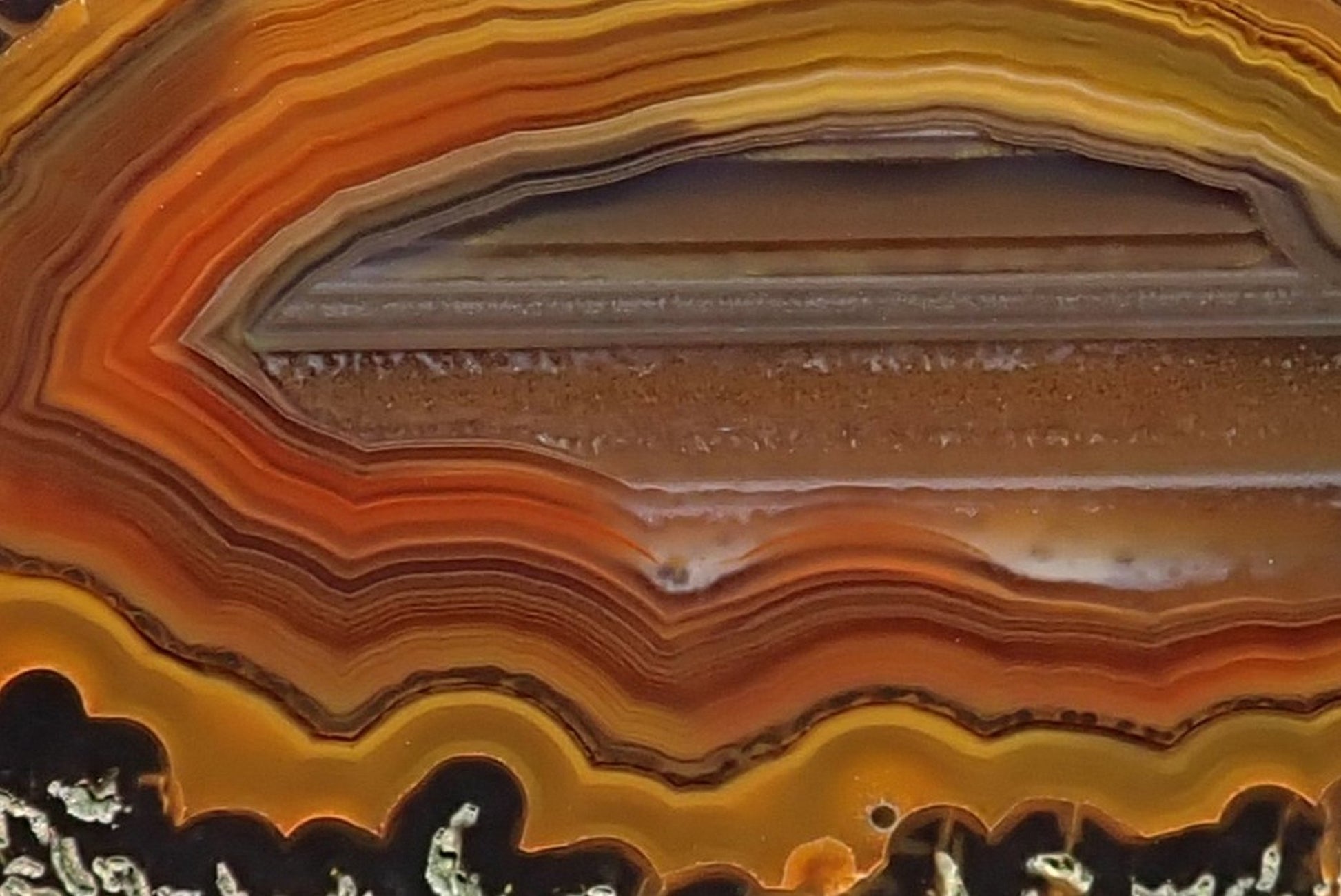 Lilangabi agate 66 mm – close-up of waterline centre and fortification banding, amber and sard-carnelian tones, Eswatini