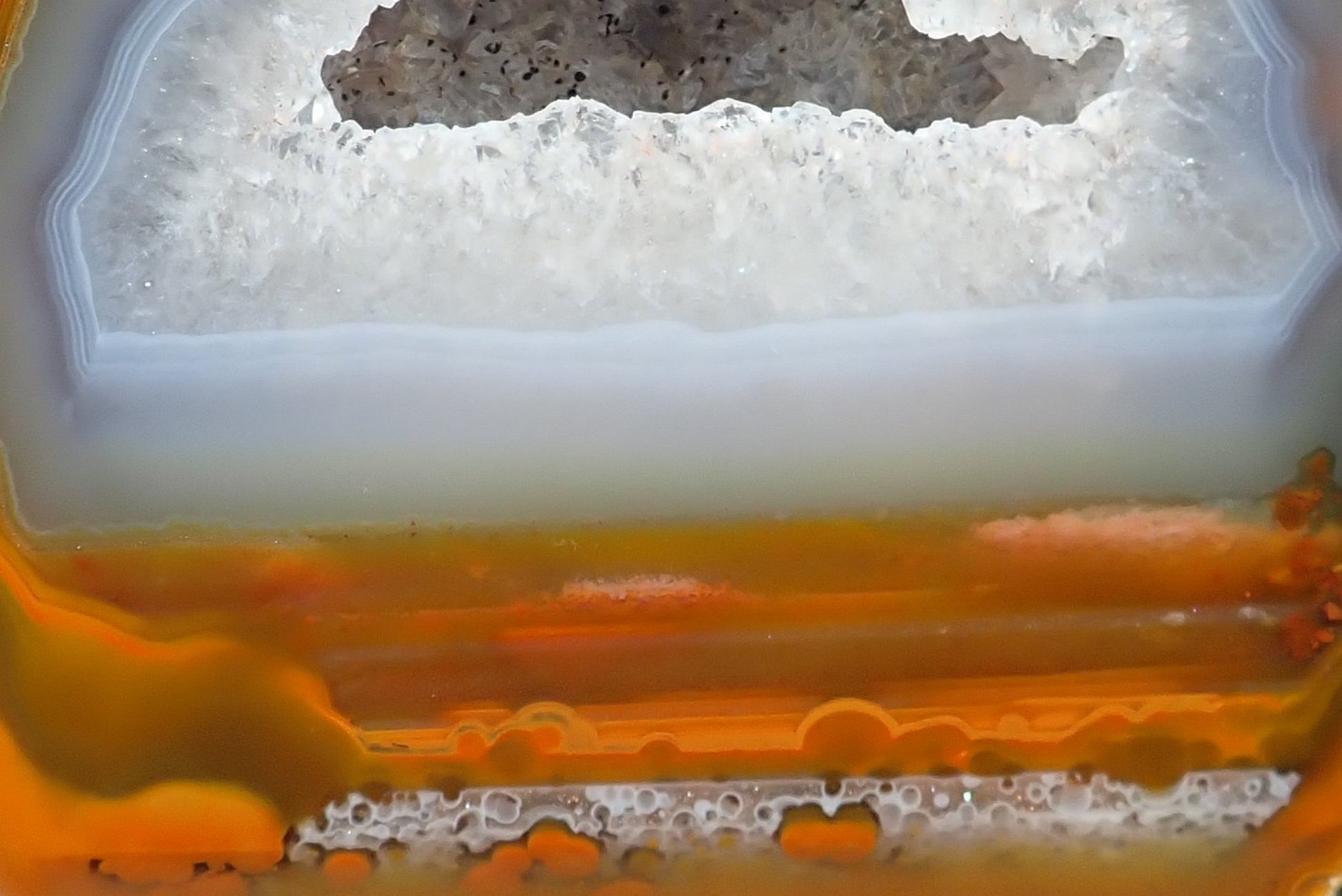 Lilangabi agate 84 mm – close-up of drusy vug, white quartz crystals with goethite specks, waterlines in lower band