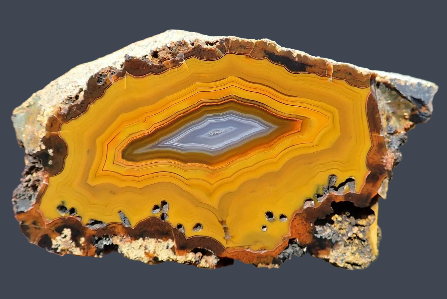 Lilangabi agate 87 mm – face view, fortification banding, blue-grey chalcedony centre with small vug, perimorphs