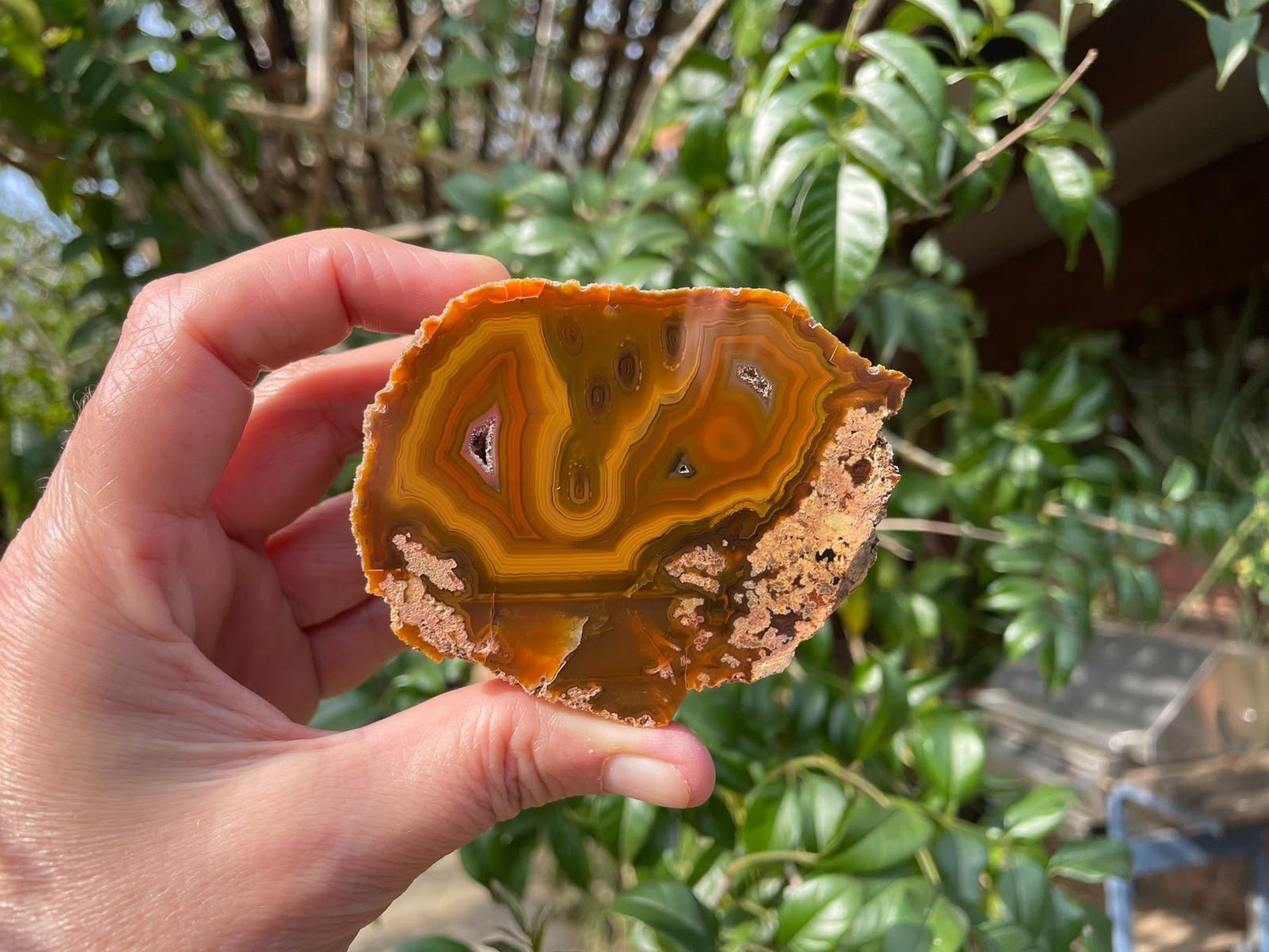 Lilangabi agate 75 mm – in-hand size reference, fortification banding, multiple vug cavities