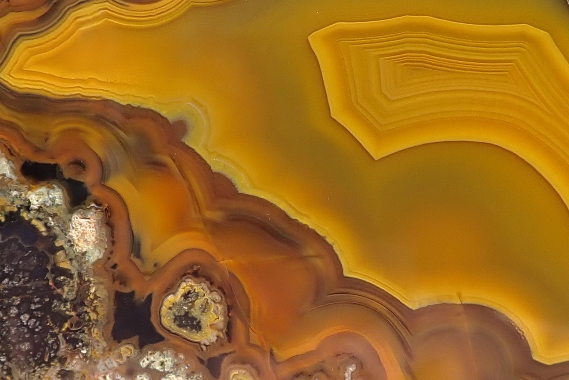 Lilangabi agate 97 mm – face detail, angular fortification banding, warm golden-yellow chalcedony centre, parallax