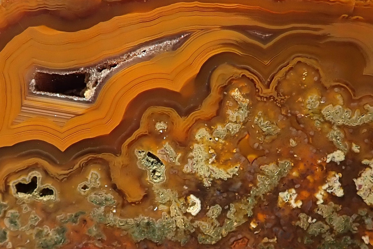 Lilangabi agate 99 mm – close-up, scalloped banding, rectangular drusy vug with dark crystalline interior, moss inclusions in sage and olive