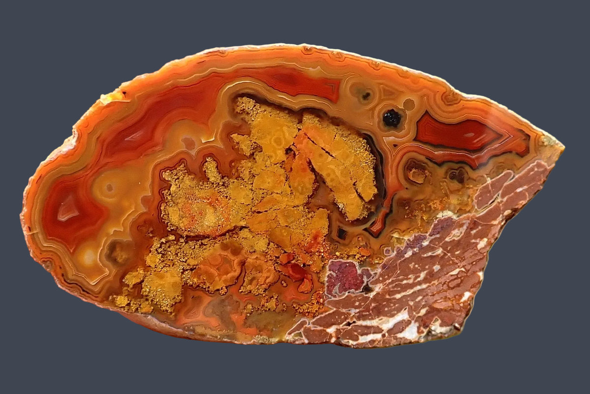 Lilangabi agate with red-to-amber chromatography, concentric banding and natural inclusions, 63 mm