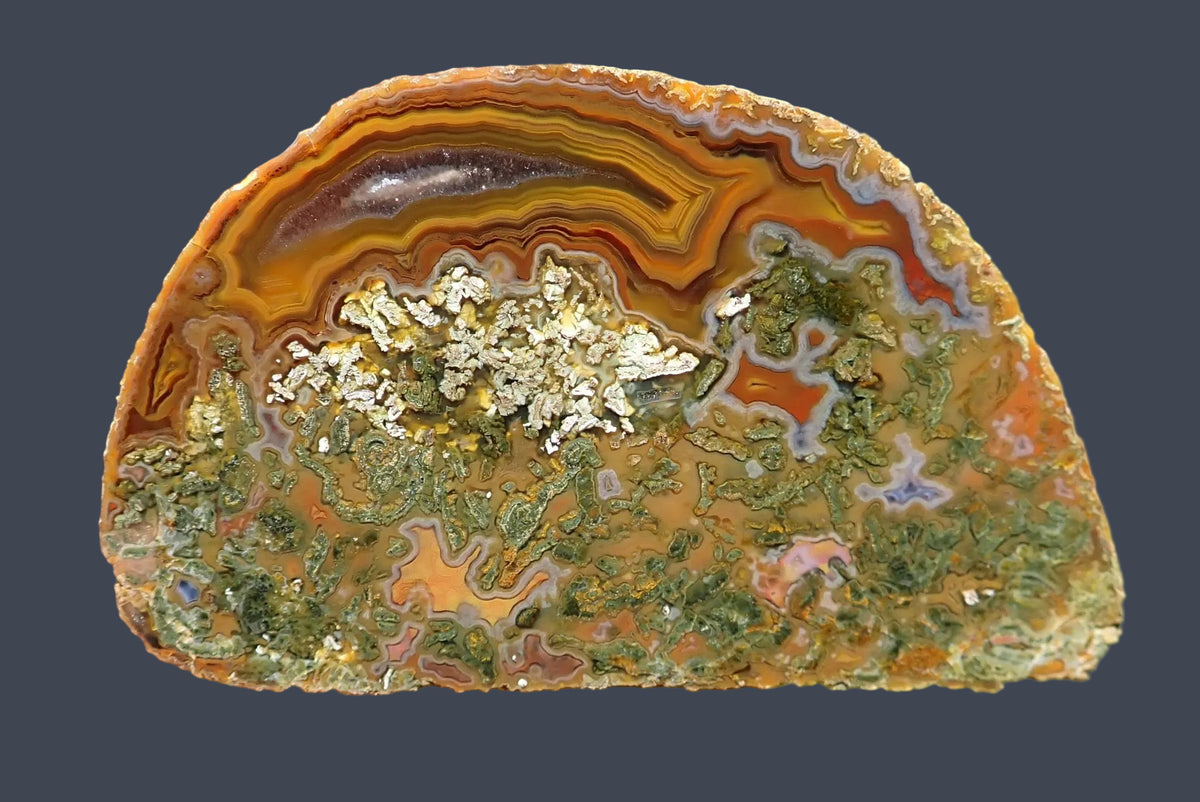 Lilangabi agate 72 mm, full face with golden-yellow, amber and orange-brown fortification banding and chromatography above green moss inclusions, with small agate chambers in the lower section.